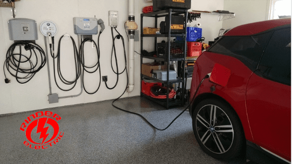 A red car is parked in front of some power cords.