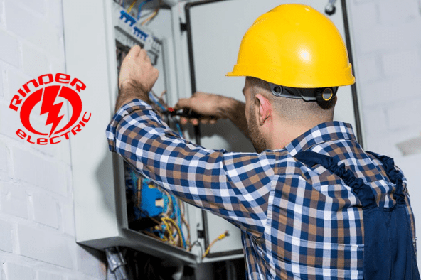 A man in a hard hat working on an electrical box.